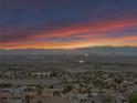 Expansive aerial shot capturing the residential area, distant mountains, and vibrant sky at dusk at 1124 Whistle Ct, Henderson, NV 89011