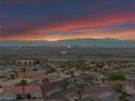 Panoramic aerial view of the neighborhood showcasing city lights and mountains at sunset at 1124 Whistle Ct, Henderson, NV 89011