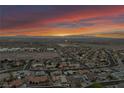 Wide aerial view of a community with a dramatic sky, highlighting mountain views and city proximity at 1124 Whistle Ct, Henderson, NV 89011