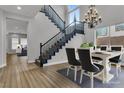Dining room with staircase and large window; modern chandelier, hardwood floors, and neutral color palette at 2805 Proust Ct, Henderson, NV 89044