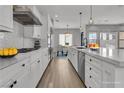 Modern kitchen with white cabinetry, stainless steel appliances, pendant lighting, and spacious quartz countertops at 2805 Proust Ct, Henderson, NV 89044