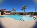 Community pool featuring crystal blue water, palm trees, cabanas, and lounge chairs for relaxation and enjoyment at 2805 Proust Ct, Henderson, NV 89044