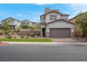Two-story home featuring neutral paint, stone accents, and brick paved driveway at 301 Resolute Ave, Henderson, NV 89011