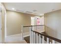 Bright hallway with white railing, neutral walls, and multiple doorways leading to other rooms upstairs at 5144 Poem Ct, North Las Vegas, NV 89081