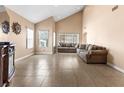 Bright living room featuring tile floors, vaulted ceiling, and neutral paint at 94 Fantasia Ln, Henderson, NV 89074