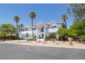 View of the front exterior featuring a three car garage and desert landscaping with palm trees at 2209 Purple Majesty Ct, Las Vegas, NV 89117