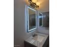 Bathroom with unique lighting, large lighted mirror, and updated countertop at 3275 Arville St # C, Las Vegas, NV 89102