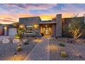 Beautiful single story home with desert landscaping, stone accents, and a brick walkway at sunset at 10018 Regency Square Ave, Las Vegas, NV 89148
