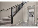 Inviting foyer with a carpeted staircase, tile flooring, and views into the open-concept living space at 10976 Bluebell Basin Rd, Las Vegas, NV 89179