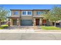 Inviting two-story home with a brick driveway, manicured lawn, and stone pillar accents at 1512 Sagefield Way, Logandale, NV 89021