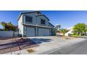 Two story home with two car garage, xeriscaping, and large driveway at 7800 Four Seasons Dr, Las Vegas, NV 89129