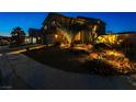 Inviting two-story home at twilight with manicured yard and landscape lighting at 7800 Four Seasons Dr, Las Vegas, NV 89129