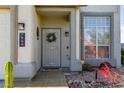 Charming front entrance featuring a decorative wreath, desert plants, and stylish exterior lighting at 7800 Four Seasons Dr, Las Vegas, NV 89129