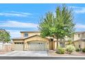 Home exterior featuring a three-car garage, landscaped yard, and a mature shade tree at 8828 Monte Oro Dr, Las Vegas, NV 89131