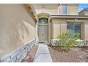 View of the home's front entrance, showcasing an arched entryway and stone accents at 8828 Monte Oro Dr, Las Vegas, NV 89131