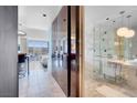 Elegant bathroom with marble tiling, glass shower, and modern lighting fixtures at 4381 W Flamingo Rd # 1109, Las Vegas, NV 89103