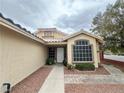 Inviting entrance with a decorative window, tiled roof, and a walkway lined with desert landscaping at 4484 Warbonnet Way, Las Vegas, NV 89147