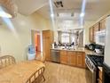 Functional kitchen featuring modern appliances, wooden cabinets, and a connected breakfast nook at 4484 Warbonnet Way, Las Vegas, NV 89147