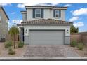 Two story house with a two car garage, tile roof, and small bushes in the landscaping at 5692 Tinar St, Las Vegas, NV 89113