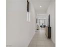 Bright hallway with modern gray console table, light tile floors, and recessed lighting at 5692 Tinar St, Las Vegas, NV 89113