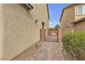 Paver pathway and metal gate leading to a private side yard with well-maintained landscaping at 10412 Deer Heights St, Las Vegas, NV 89178