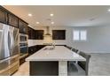 Bright kitchen with stainless steel appliances, quartz countertops, and a spacious island with bar seating at 1128 Via Della Curia, Henderson, NV 89011