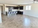 Spacious open-concept living room featuring a modern kitchen and tile flooring at 1128 Via Della Curia, Henderson, NV 89011