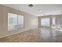 Bright living room with neutral walls, tile flooring, and large windows offering ample natural light for comfortable living at 1531 Evening Spirit Ave, Las Vegas, NV 89183