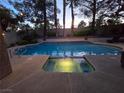 Backyard pool with a hot tub, illuminated by underwater lights for evening enjoyment at 2065 Pinion Springs Dr, Henderson, NV 89074