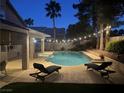 Night view of backyard featuring a sparkling pool, spa, and ambient string lights at 2065 Pinion Springs Dr, Henderson, NV 89074
