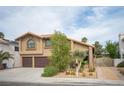 Inviting home with desert landscaping, two-car garage, and a secure gated entrance to the backyard at 220 Hollyfern St, Henderson, NV 89074