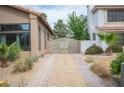 View of the gated driveway leading to the backyard, featuring desert landscaping and pavers at 220 Hollyfern St, Henderson, NV 89074