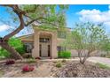 Home exterior showcasing a well-manicured lawn, mature trees, and a charming covered entryway at 2424 Chestnut Hill St, Las Vegas, NV 89134