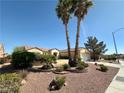 Inviting single-story home featuring mature landscaping and palm trees in a well-maintained yard at 2558 Grandville Ave, Henderson, NV 89052