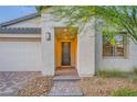 Inviting front entrance with stone steps, desert landscaping, and a two-car garage at 26 Sun Mirage Ave, Henderson, NV 89011