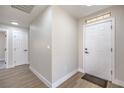 Inviting entryway featuring light wood-look floors and a modern white front door at 2629 Blue Reef Dr, North Las Vegas, NV 89032