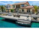 Beautiful backyard featuring a wooden deck on the canal with seating and a canoe at 2708 Port Of Call Dr, Las Vegas, NV 89128