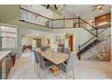 Open-concept dining area with stone accents, a staircase, and view of the living area, creating a welcoming atmosphere at 2708 Port Of Call Dr, Las Vegas, NV 89128