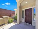 Beautiful covered entry with a dark wood door, complemented by attractive landscaping at 2713 Rue Toulouse Ave, Henderson, NV 89044