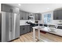 Bright kitchen with stainless steel refrigerator, gray cabinets and eat in counter at 2724 Spear St, North Las Vegas, NV 89030