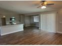 Bright, open living room features wood-look floors, ceiling fan, and modern kitchen in the background at 3016 Mount Charleston Dr, Pahrump, NV 89048