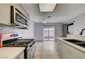 Modern kitchen with stainless steel appliances, gas range, mosaic backsplash, and sliding door to patio at 441 N Lamb Blvd # E, Las Vegas, NV 89110