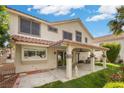 Backyard with a covered patio, lush green lawn, and mature trees, perfect for outdoor living at 5148 Forest Oaks Dr, Las Vegas, NV 89149