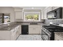 Bright kitchen featuring granite countertops, modern appliances, white cabinets, and tile backsplash at 5148 Forest Oaks Dr, Las Vegas, NV 89149
