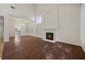 Bright living room with wood floors, a fireplace, large windows, and an elegant chandelier at 5148 Forest Oaks Dr, Las Vegas, NV 89149