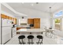 Bright kitchen features wood cabinets, white appliances, tiled floors, and a breakfast bar at 5224 Dana Springs Way, Las Vegas, NV 89130