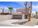 Charming two-story home with tile roof, desert landscaping, and attached two car garage at 5853 Calobar Ln, Las Vegas, NV 89110
