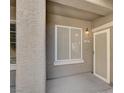 Inviting entrance to unit 103 featuring beige stucco and a storm door at 6680 Caporetto Ln # 103, North Las Vegas, NV 89084