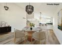 Open dining area featuring a glass table, modern lighting, and access to the kitchen at 744 Willow Ave, Henderson, NV 89002