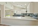Bright kitchen featuring a breakfast bar, stainless appliances, and stylish backsplash at 744 Willow Ave, Henderson, NV 89002